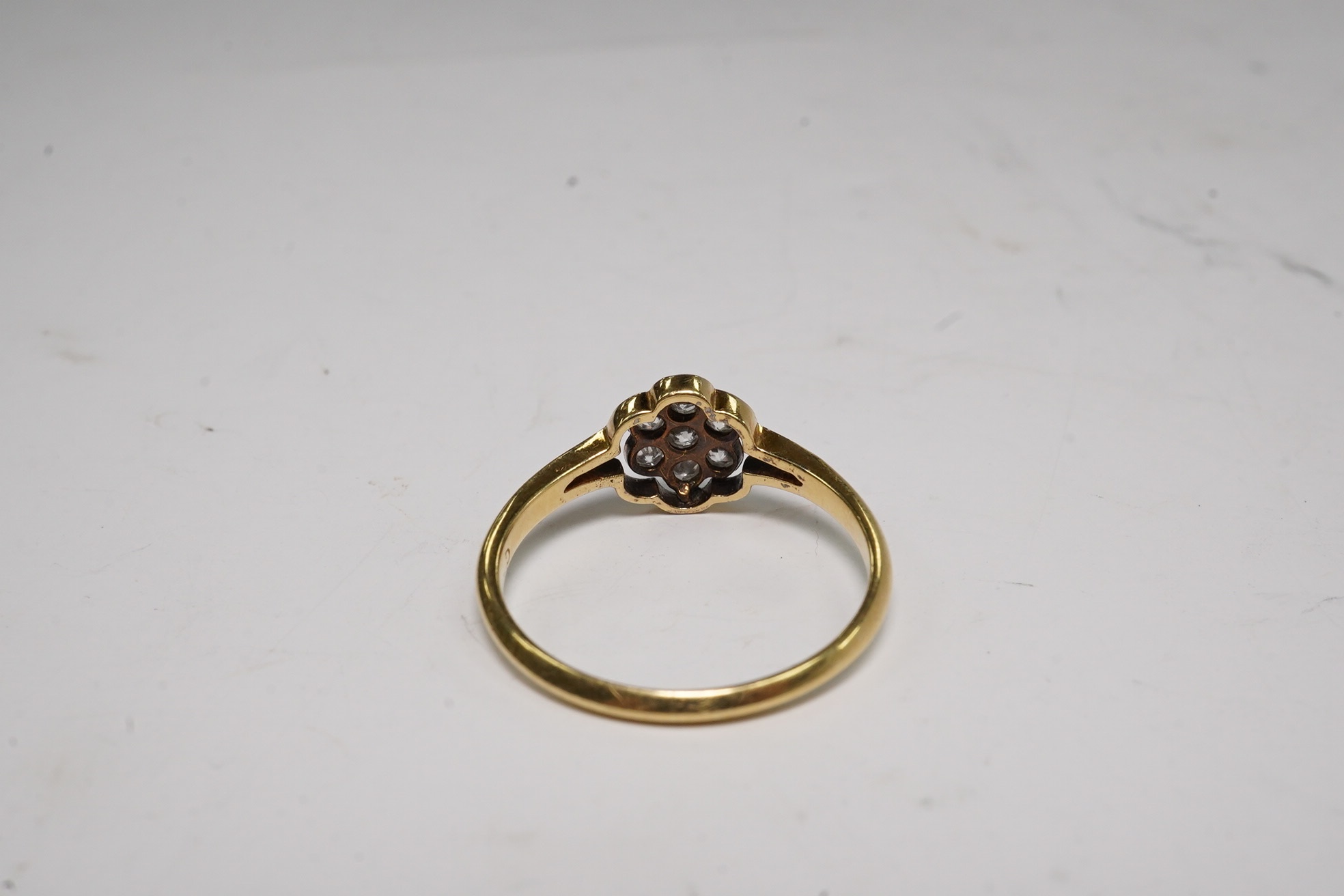 A 1940's 18ct, plat and diamond set flower head cluster ring, size O, gross weight 2.1 grams.